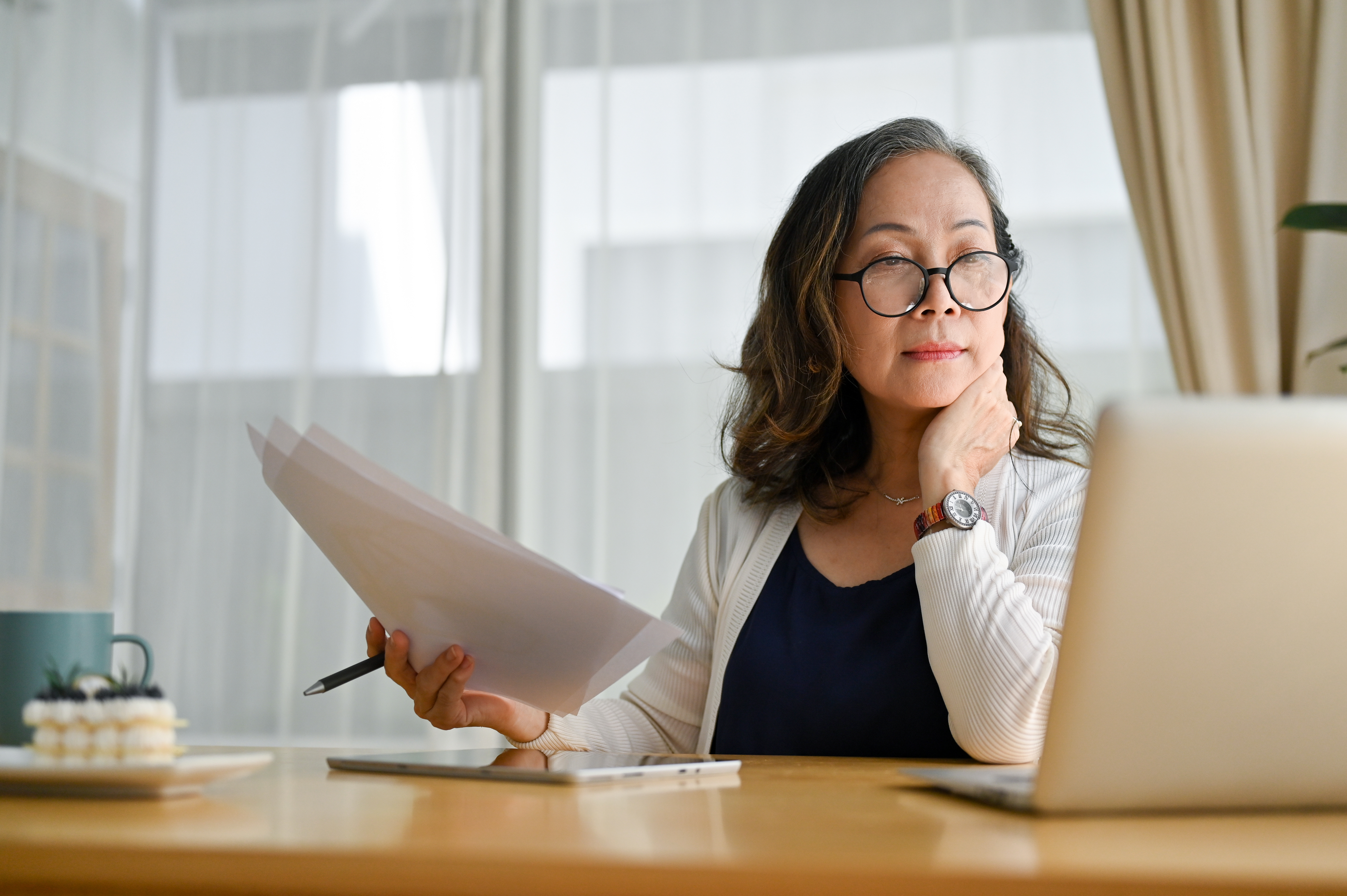 Woman at laptop with notes