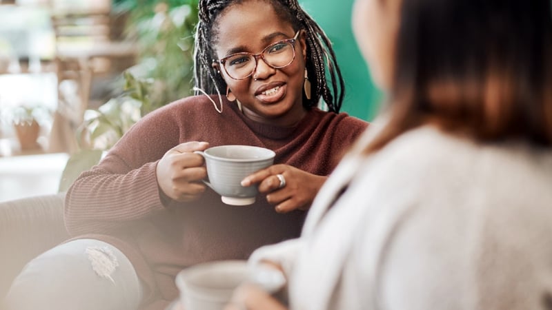 Two female colleagues chatting and having coffee