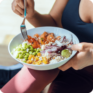 Person in gym clothes eating healthy bowl of food