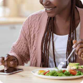 a woman using her smartphone while eating a salad